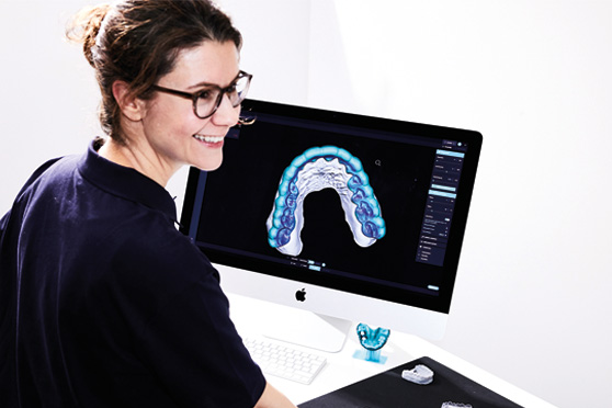 一名实验室工作人员正在使用DentaMile connec t软件